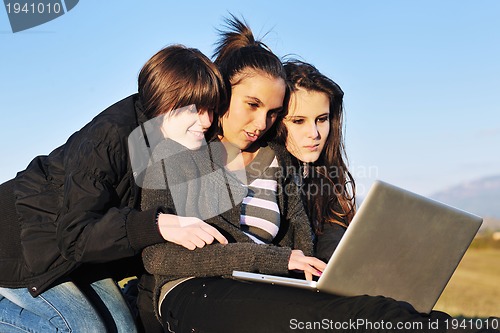 Image of group of teens working on laptop outdoor