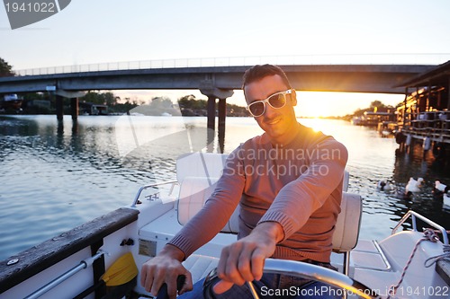 Image of portrait of happy young man on boat