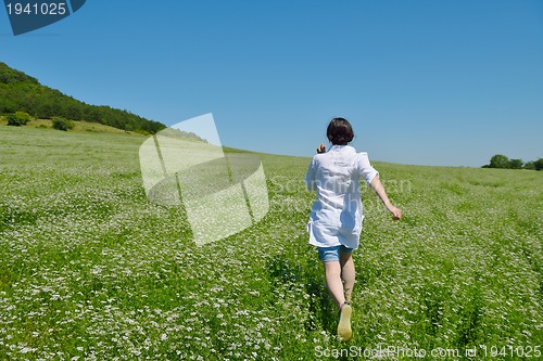 Image of Young happy woman in green field