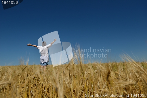 Image of young woman in wheat field at summer