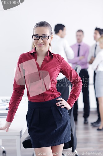 Image of business woman standing with her staff in background