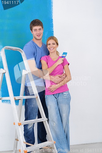 Image of happy couple paint wall at new home
