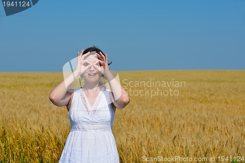 Image of young woman in wheat field at summer
