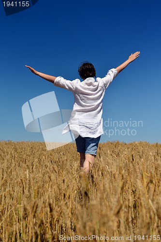 Image of young woman in wheat field at summer