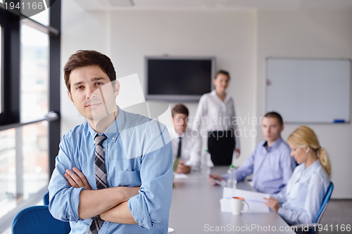 Image of business man  on a meeting in offce with colleagues in backgroun