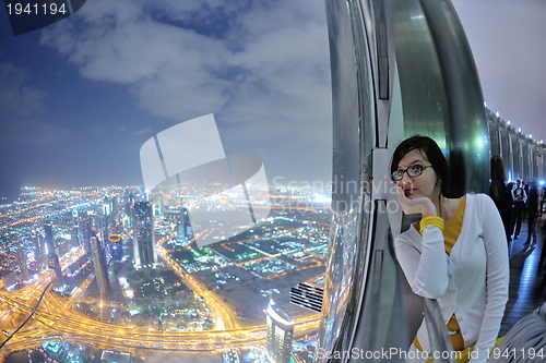 Image of beautiful woman portrait with big city at night in background