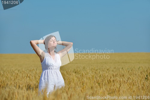 Image of young woman in wheat field at summer