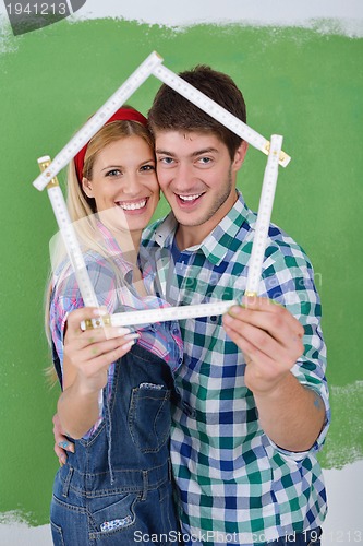 Image of happy couple paint wall at new home