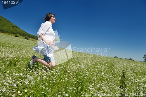 Image of Young happy woman in green field