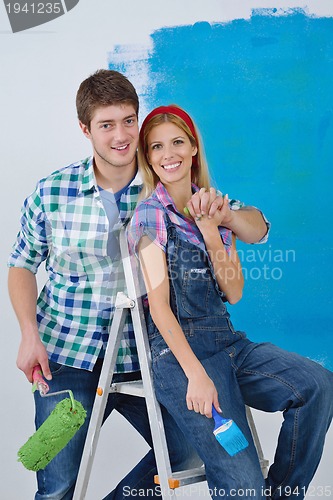 Image of happy couple paint wall at new home