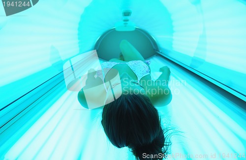 Image of Beautiful young woman tanning in solarium