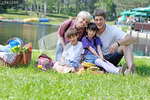 Image of Happy family playing together in a picnic outdoors
