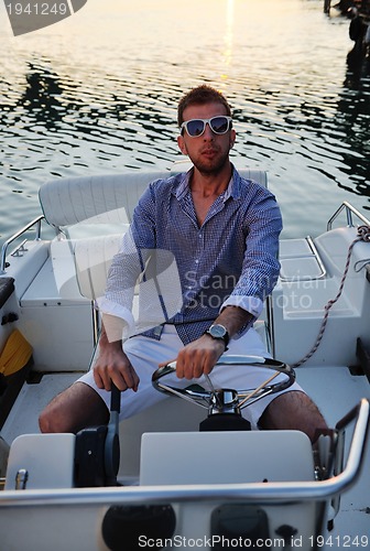 Image of portrait of happy young man on boat