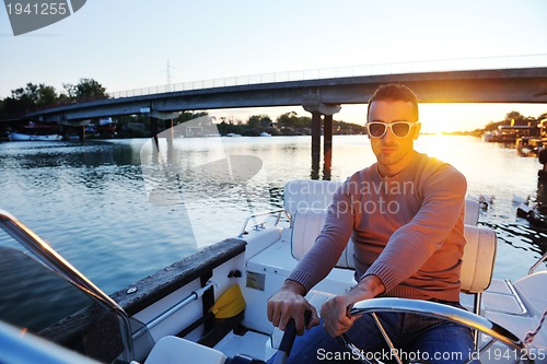 Image of portrait of happy young man on boat
