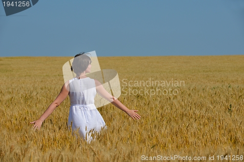 Image of young woman in wheat field at summer