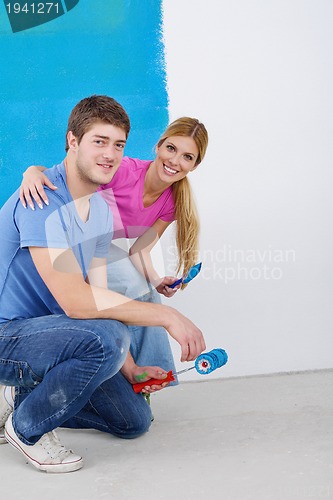 Image of happy couple paint wall at new home