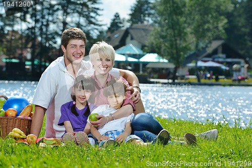 Image of Happy family playing together in a picnic outdoors