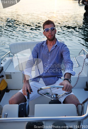 Image of portrait of happy young man on boat