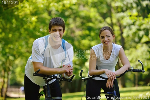 Image of Happy couple ridine bicycle outdoors