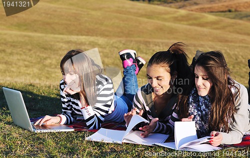 Image of group of teens working on laptop outdoor