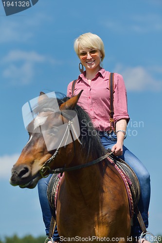 Image of happy woman  on  horse