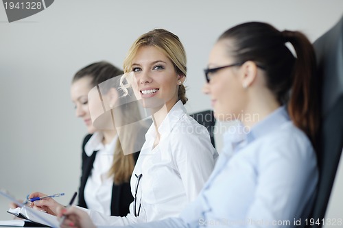 Image of business woman standing with her staff in background