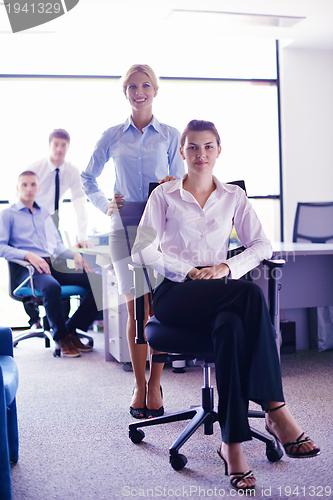 Image of business woman with her staff in background at office