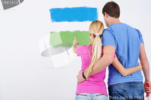 Image of happy couple paint wall at new home