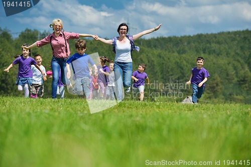 Image of happy kids group with teacher in nature