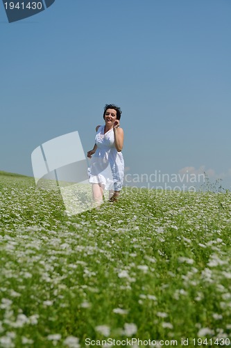 Image of Young happy woman in green field