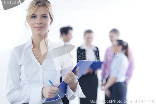 Image of business woman standing with her staff in background