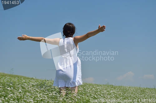 Image of Young happy woman in green field