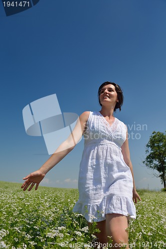 Image of Young happy woman in green field