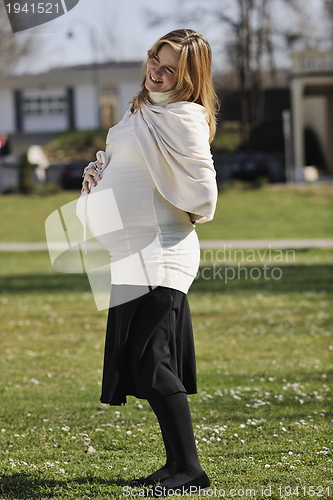 Image of happy young pregnant woman outdoor