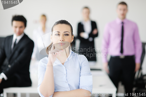 Image of business woman standing with her staff in background
