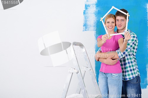 Image of happy couple paint wall at new home