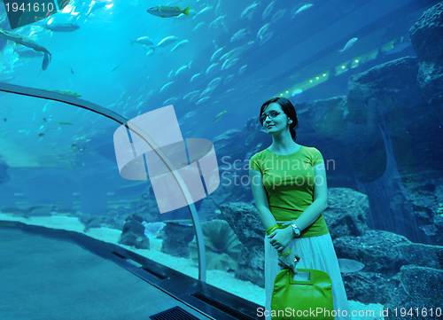 Image of young woman with big aquarium in backgrond