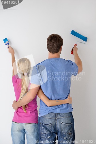 Image of happy couple paint wall at new home