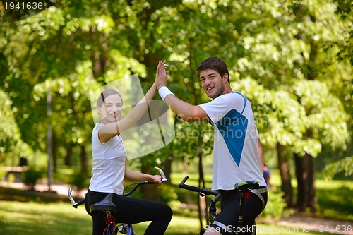 Image of Happy couple ridine bicycle outdoors