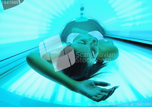 Image of Beautiful young woman tanning in solarium