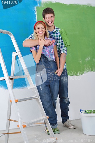 Image of happy couple paint wall at new home