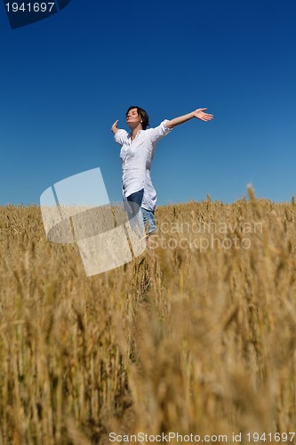 Image of young woman in wheat field at summer