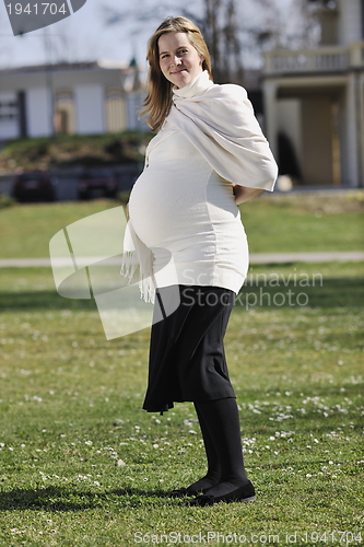 Image of happy young pregnant woman outdoor