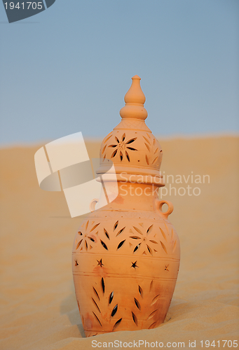 Image of arabic pot in sand