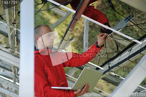 Image of engineer using laptop at solar panels plant field