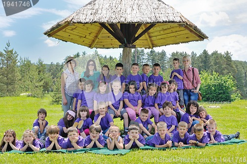 Image of happy kids group with teacher in nature