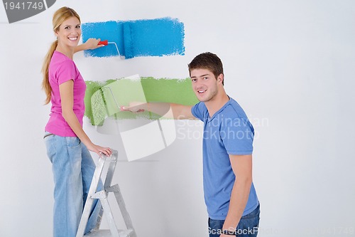 Image of happy couple paint wall at new home