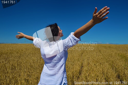 Image of young woman in wheat field at summer