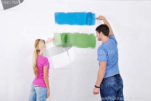 Image of happy couple paint wall at new home