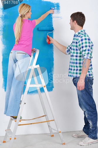 Image of happy couple paint wall at new home